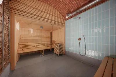 a sauna with a bench and a shower in a room at Palace Dlazdena – Stylish Prague Centre Apartment in Prague