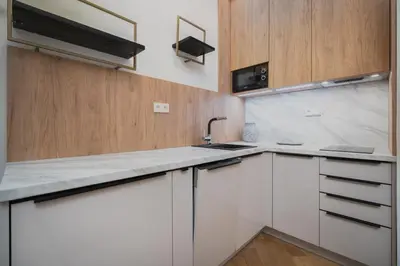 a kitchen with white cabinets and a sink at Palace Dlazdena – Stylish Prague Centre Apartment in Prague
