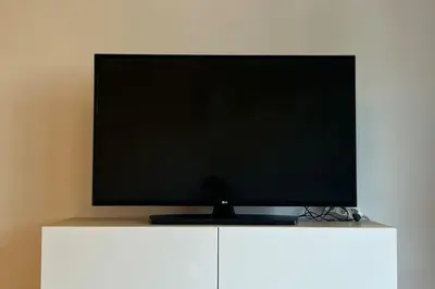 a flat screen tv sitting on top of a white cabinet at Residence Garden Tower - Parking in Prague