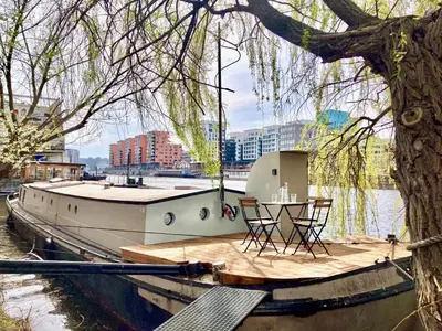 a boat with a table and chairs on a dock at Prague on Boat, Privat Pier, Free Parking in Prague