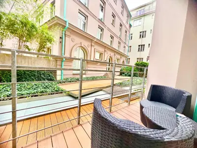 a balcony with two chairs and a garden at exclusive apartment centrum Prague in Prague