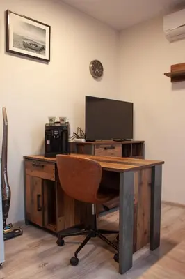 a room with a desk with a television and a bed at Ubytování 1kk ve Zlonicích in Slaný