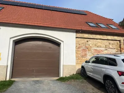 a car parked in front of a garage at Ubytování 1kk ve Zlonicích in Slaný