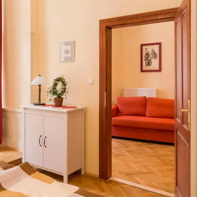 a living room with a red couch and a mirror at Stella apartments in Prague