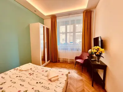 a bedroom with a bed and a table and a window at Modern apartment Na Hluboké in Prague in Prague