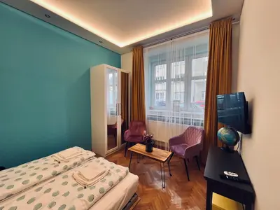 a bedroom with a bed and two chairs and a window at Modern apartment Na Hluboké in Prague in Prague