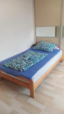 a bed with a blue comforter on top of it at Spacious Rooms in Prague 6 near center in Prague