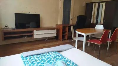 a living room with a television and a table and chairs at Spacious Rooms in Prague 6 near center in Prague
