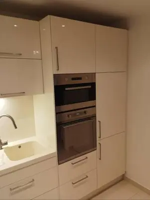 a kitchen with white cabinets and a stove and a sink at Spacious Rooms in Prague 6 near center in Prague