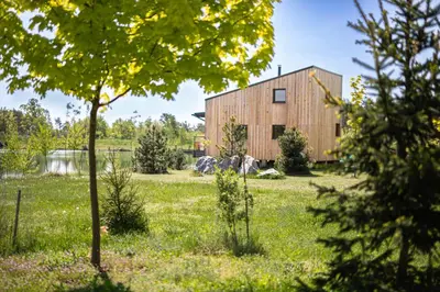 a barn in the middle of a field with trees at RESORT SALIXA u Poděbrad in Poděbrady