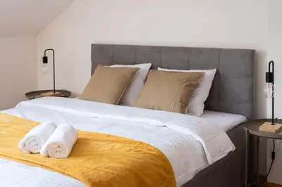 a bedroom with a large bed with towels on it at 2-level apartment with large balcony in Prague