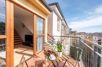 a balcony with a table and chairs at 2-level apartment with large balcony in Prague
