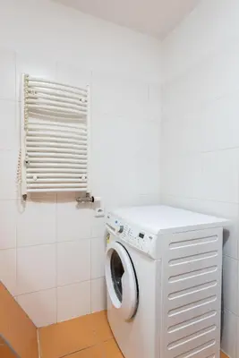 a washing machine in a bathroom with a window at 2-level apartment with large balcony in Prague