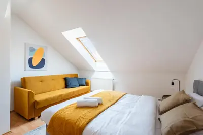 a bedroom with a bed and a couch at 2-level apartment with large balcony in Prague