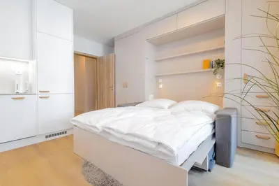 a white bedroom with a bed with white walls at Yellow Apartment - Balcony, Free Parking, by Gravity Prague in Prague