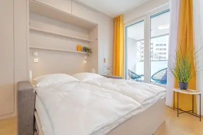 a white bed in a room with a window at Yellow Apartment - Balcony, Free Parking, by Gravity Prague in Prague