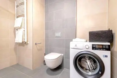 a bathroom with a washing machine and a toilet at Yellow Apartment - Balcony, Free Parking, by Gravity Prague in Prague