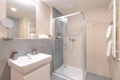 a bathroom with a shower and a sink and a mirror at Yellow Apartment - Balcony, Free Parking, by Gravity Prague in Prague