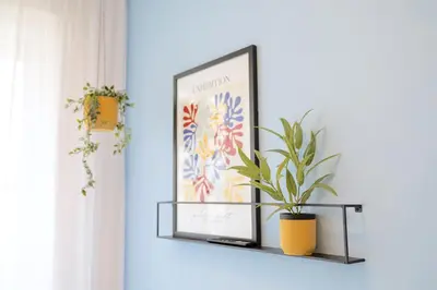 a shelf with a picture and a plant on it at Yellow Apartment - Balcony, Free Parking, by Gravity Prague in Prague