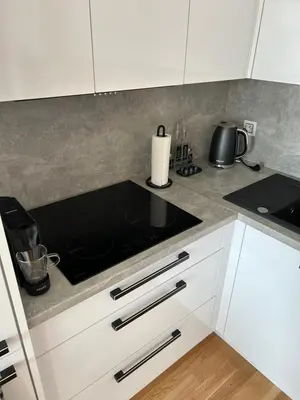 a kitchen with white cabinets and a stove top at Prague Smíchov Anděl Apartment in Prague