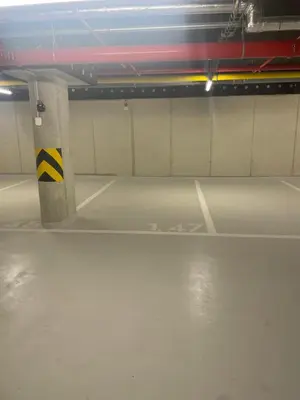 an empty parking garage with a yellow and black pole at Prague Smíchov Anděl Apartment in Prague