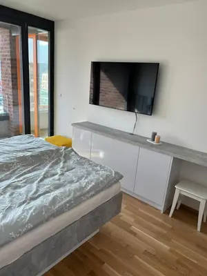 a bedroom with a bed and a tv on a wall at Prague Smíchov Anděl Apartment in Prague