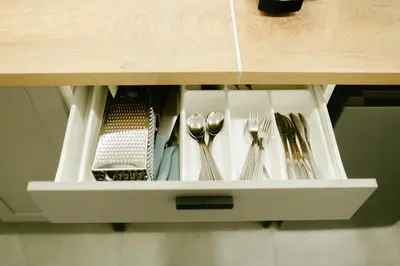 a drawer with silver utensils in a cabinet at Godiland Apartment in Prague
