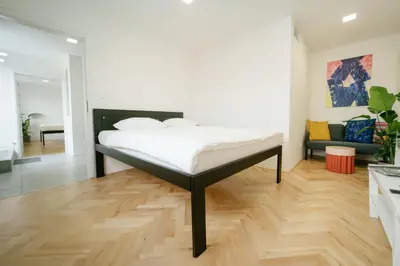 a bedroom with a bed and a living room at Godiland Apartment in Prague