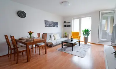 a living room with a table and a couch at Apartmán u METRA, 4 hosté, parking free, blízko O2 arena in Prague