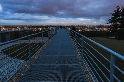 a walkway with a view of a city at night at Apartmán u METRA, 4 hosté, parking free, blízko O2 arena in Prague