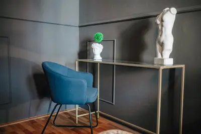 a room with a blue chair and a shelf with a plant at Royal Heritage Apartments - City Centre in Prague