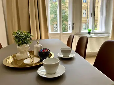 a table with two cups and a vase on it at Royal Heritage Apartments - City Centre in Prague