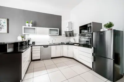 a kitchen with white cabinets and a stainless steel refrigerator at Royal Heritage Apartments - City Centre in Prague