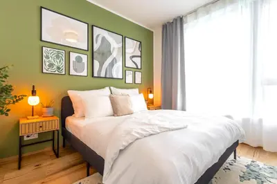 a bedroom with a white bed and a green wall at Stylish Apartment - Free Parking, Cinema, by Gravity Prague in Prague