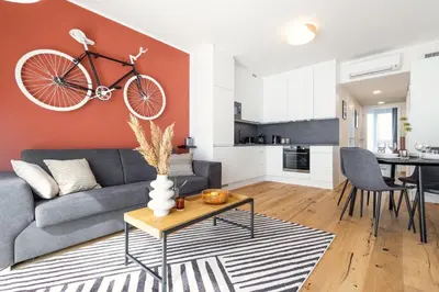 a living room with a couch and a bike on the wall at Stylish Apartment - Free Parking, Cinema, by Gravity Prague in Prague