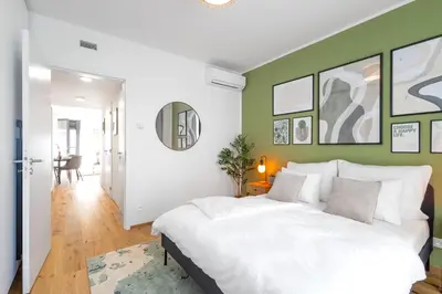 a bedroom with a white bed and green walls at Stylish Apartment - Free Parking, Cinema, by Gravity Prague in Prague
