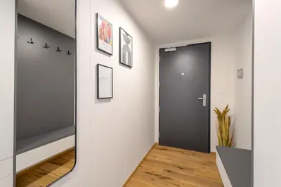a hallway with a black door and a mirror at Stylish Apartment - Free Parking, Cinema, by Gravity Prague in Prague
