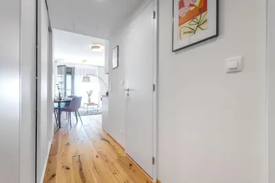 a hallway with white walls and a wooden floor at Stylish Apartment - Free Parking, Cinema, by Gravity Prague in Prague