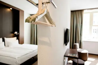 a hotel room with a bed and two windows at Motel One Prague-Florentinum in Prague