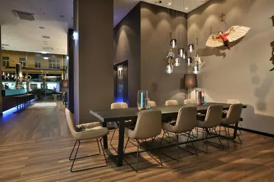 a living room with a couch and tables and a mirror at Motel One Prague-Florentinum in Prague
