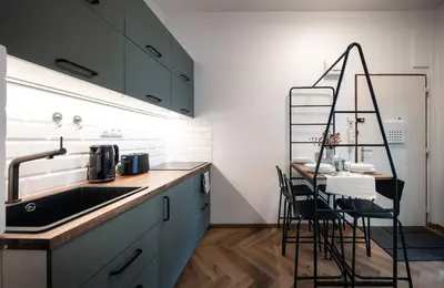 a kitchen with a sink and a counter with chairs at 2BR 1,5Bath Chic City Suite near Wenceslas Square in Prague