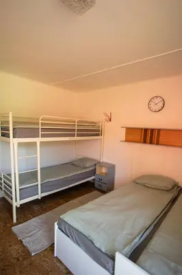 two bunk beds in a room with a clock on the wall at Prague Camping Dzban in Prague