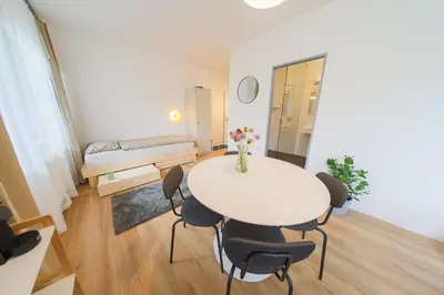a white table and chairs in a room with a bed at Prague Camping Dzban in Prague