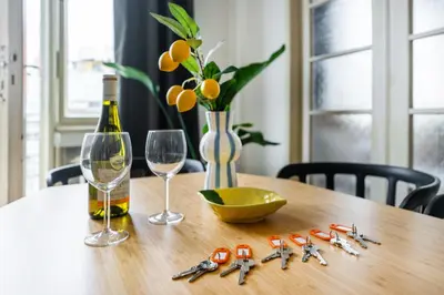 a wooden table with a bottle of wine and glasses at La Terrasse Apartment Prague center in Prague