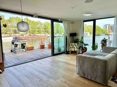 a living room with a couch and a view of the water at One of the kind Prague Houseboat Experience +BOAT in Prague