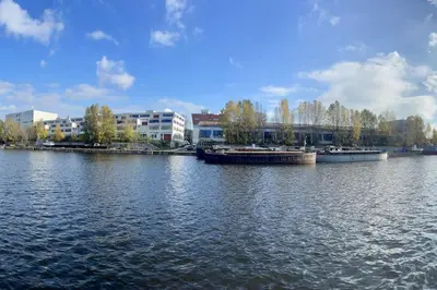two boats are docked on a river with buildings at One of the kind Prague Houseboat Experience +BOAT in Prague