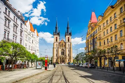 a street with a church with a clock tower at One of the kind Prague Houseboat Experience +BOAT in Prague