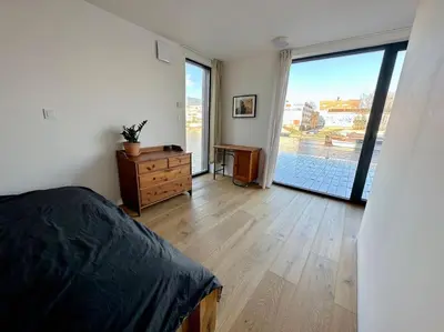 a bedroom with a bed and a large sliding glass door at One of the kind Prague Houseboat Experience +BOAT in Prague