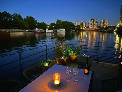 a table with wine glasses and a candle on a deck at One of the kind Prague Houseboat Experience +BOAT in Prague