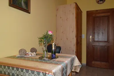 a table with a vase of flowers and a bottle of wine at Šestajovický pivovar ubytování in Šestajovice